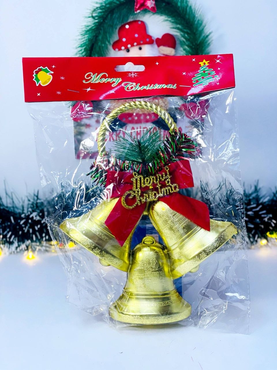 جرس الكريسماس البلاستيك الذهبي مع فيونكة حمراء وعبارة Merry Christmas